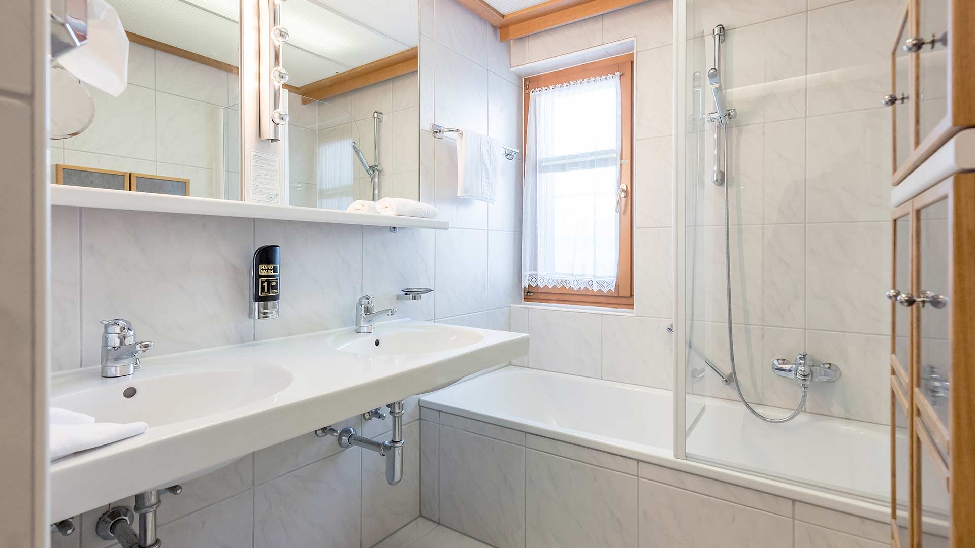 Spacious bath room with plenty storage facilities, bath tube, shower, double washing basing