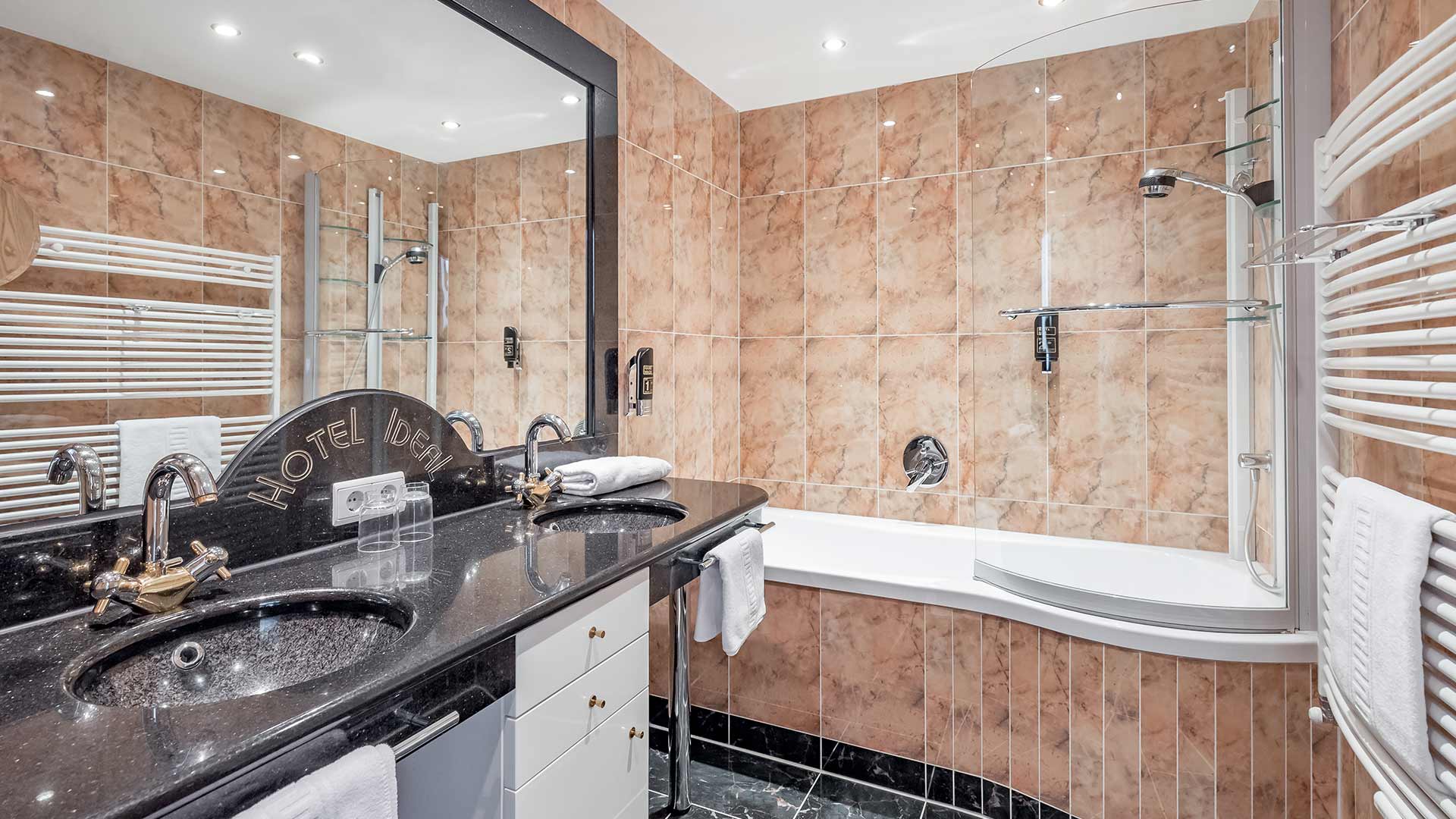Luxuriöses Badezimmer mit Doppelwaschbecken, Badewanne und separatem WC